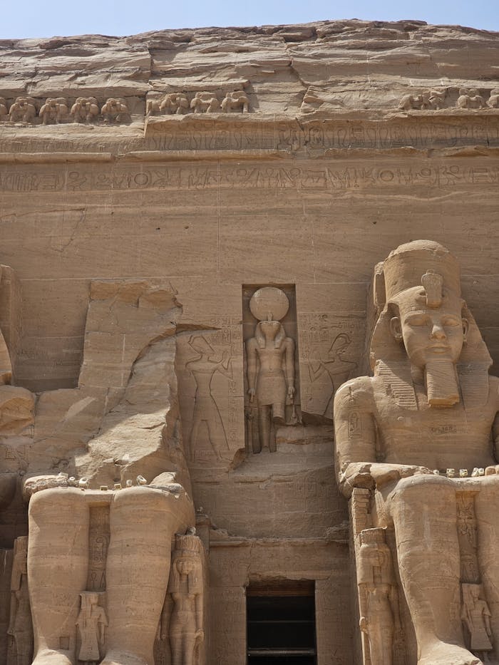 Services Ancient Egyptian pharaoh statues at the Abu Simbel temple in sunlight.