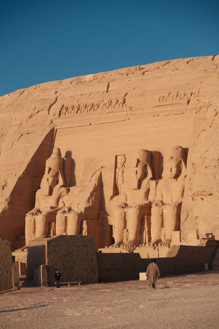 Services Stunning shot of Abu Simbel Temples with ancient statues, under clear blue sky.